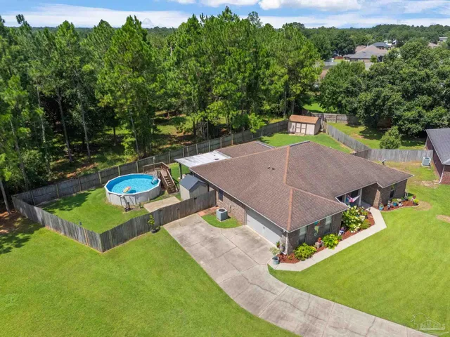an aerial view of a house with a yard and lake view
