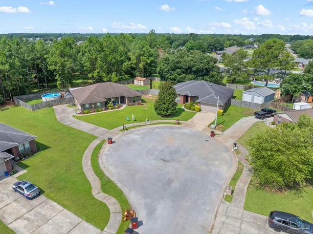 an aerial view of residential houses with outdoor space and parking