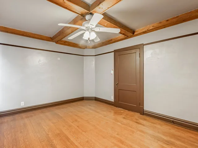 an empty room with a ceiling fan and a window