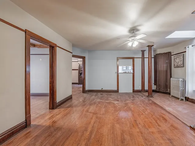 a view of empty room with wooden floor and window