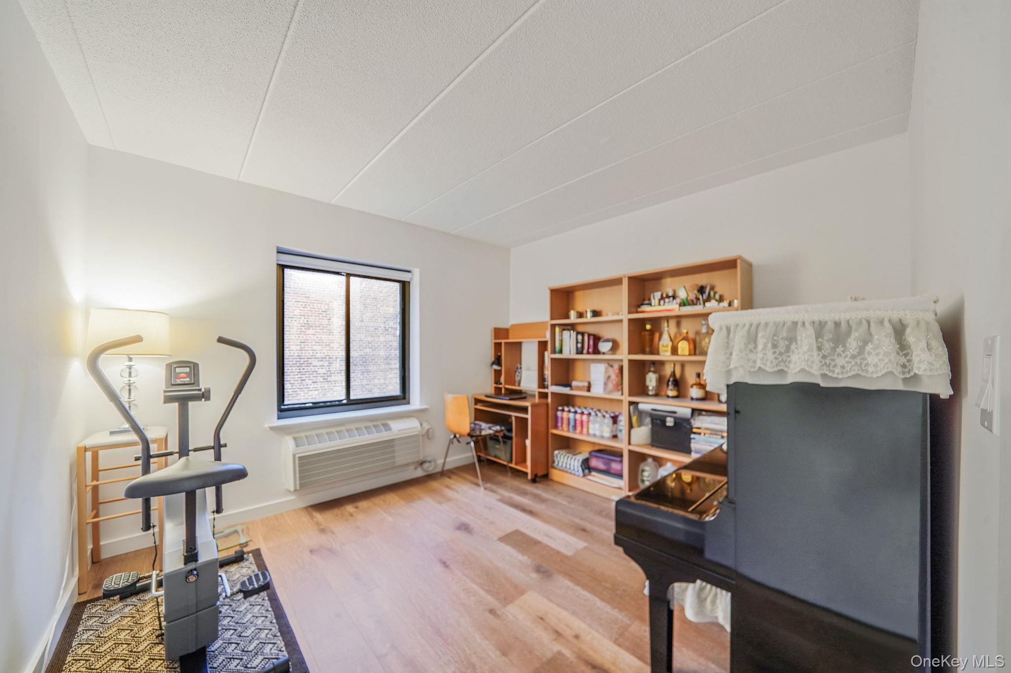 213-02 42nd Avenue, Unit 2A Queens, NY 11361 - Photo 13 of 24 a living room with furniture and a wooden floor