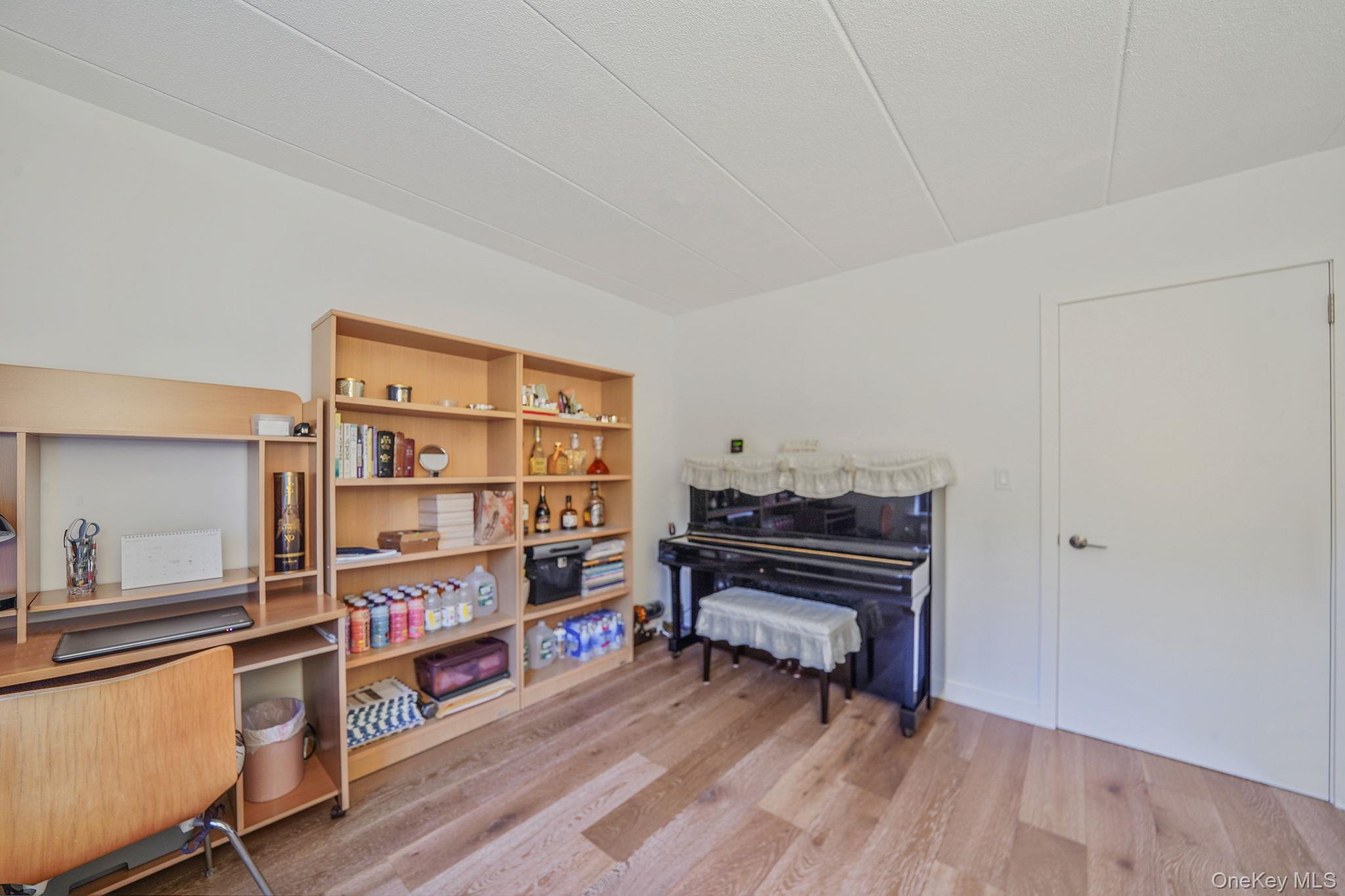 213-02 42nd Avenue, Unit 2A Queens, NY 11361 - Photo 14 of 24 a view of a workspace with furniture and wooden floor