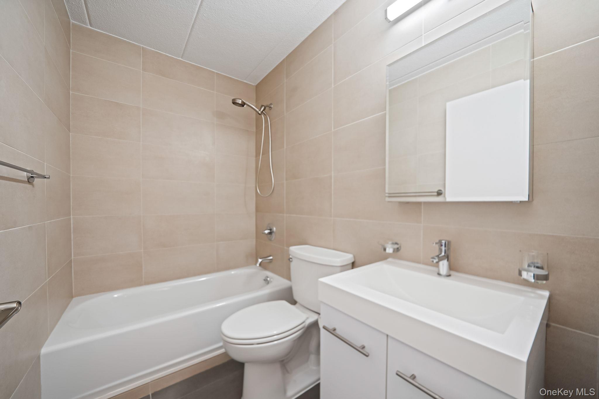 213-02 42nd Avenue, Unit 2A Queens, NY 11361 - Photo 21 of 24 a bathroom with a sink a toilet and shower