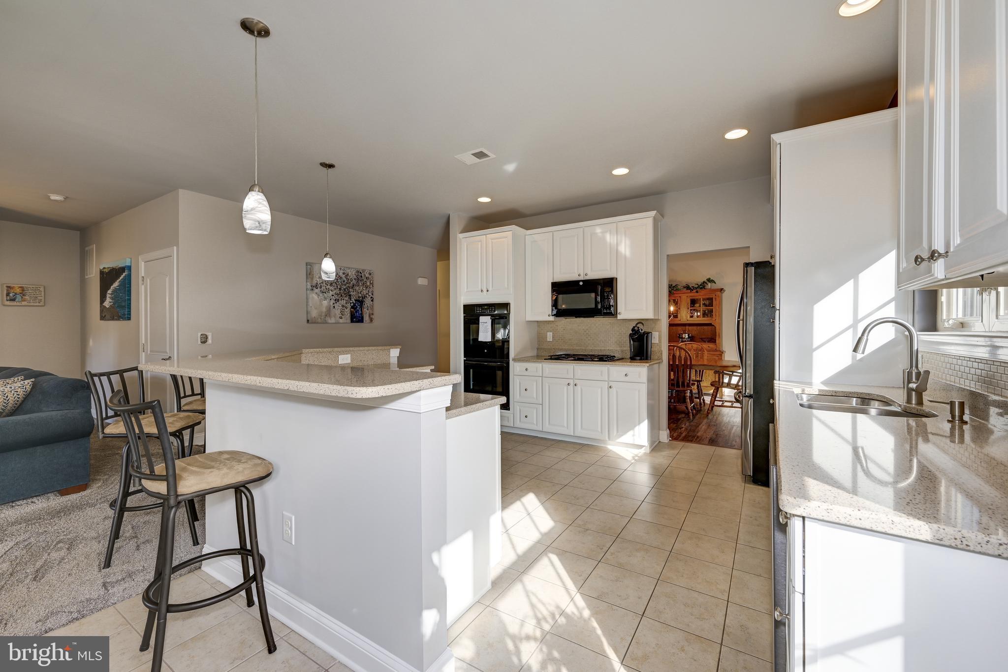 18 Genova Drive West Berlin, NJ 08091 - Photo 17 of 49 a kitchen with stainless steel appliances kitchen island granite countertop a sink and a refrigerator