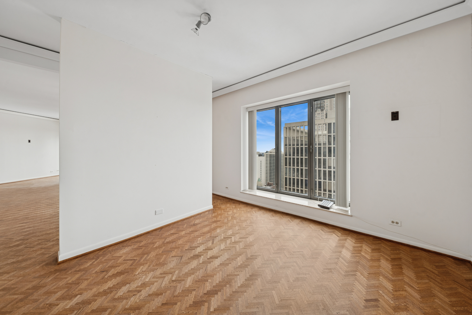 950 North Michigan Avenue, Unit 3104 Chicago, IL 60611 - Photo 12 of 28 a view of an empty room with wooden floor and a window