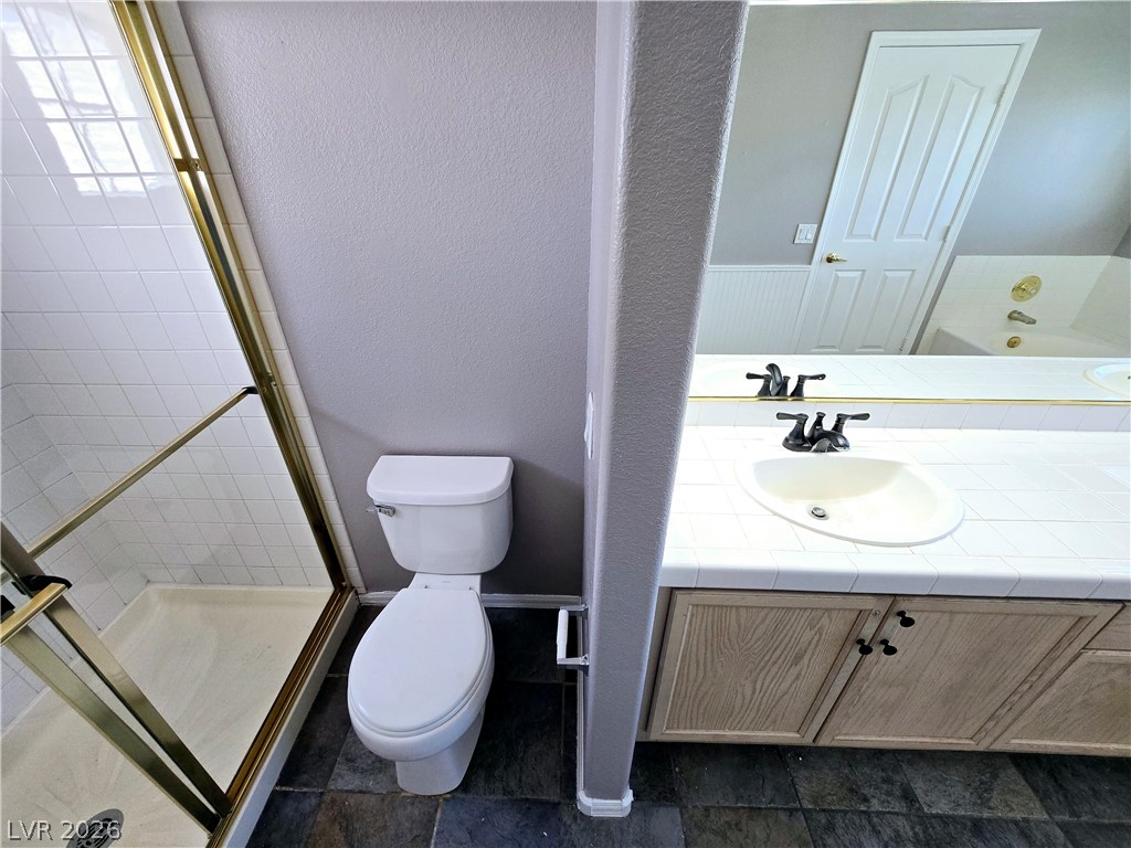 3759 Funston Way Las Vegas, NV 89129 - Photo 9 of 31 Functional primary bathroom featuring a tiled shower and vanity with a well-lit mirror.