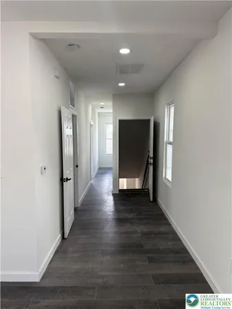 a view of a hallway with wooden floor