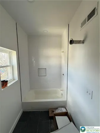 a bathroom with a bathtub and a shower