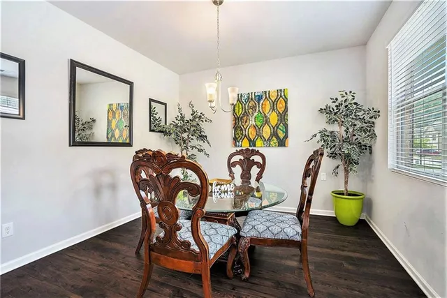 a view of a dining room with furniture a chandelier and wooden floor