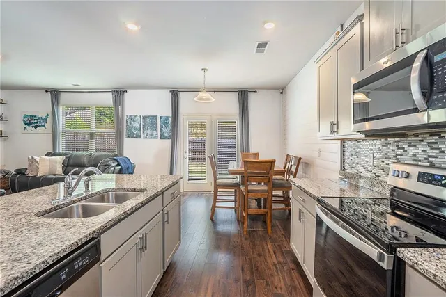a kitchen with stainless steel appliances granite countertop a sink stove and cabinets