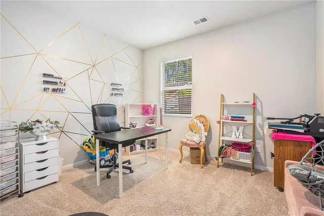 a view of a workspace with furniture and a window