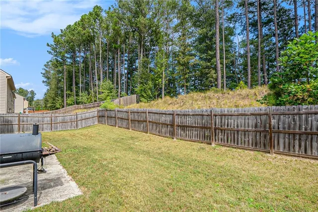 a view of backyard with swimming pool and trees