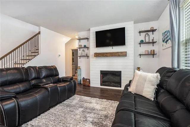 a living room with furniture a flat screen tv and a fireplace