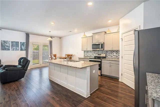 a kitchen with kitchen island granite countertop a sink stove and refrigerator