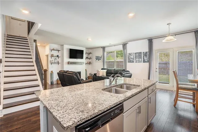 a kitchen with granite countertop a sink and a refrigerator
