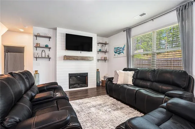 a living room with furniture a flat screen tv and a fireplace