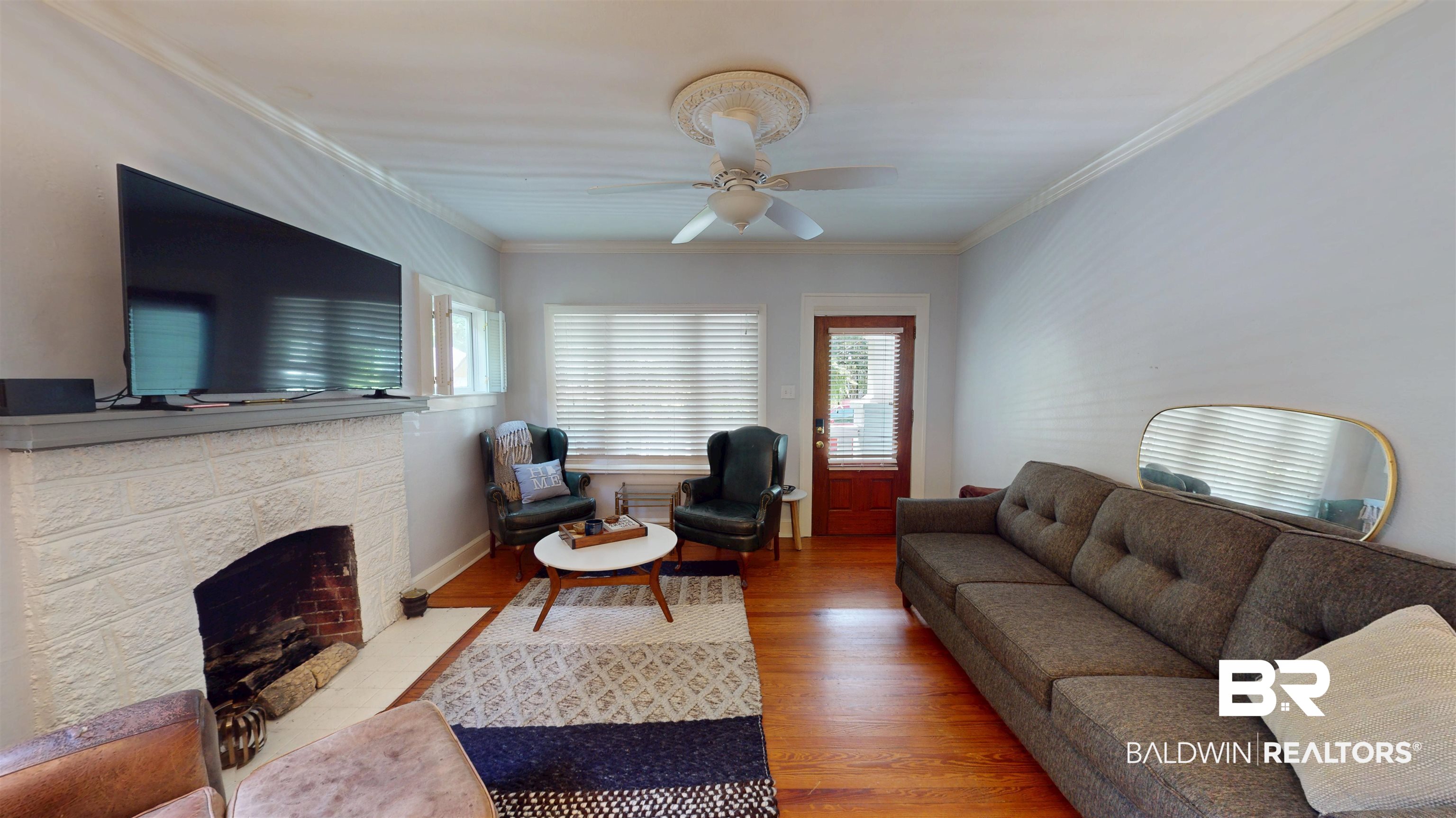 266 Westwood Street Mobile, AL 36606 - Photo 7 of 34 Living area featuring wood finished floors, a ceiling fan, a fireplace, and ornamental molding