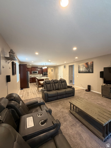 118 Tram Rock Rd. Lake Point, UT 84074 - Photo 14 of 34 Open-concept living space featuring recessed lighting, a neutral color palette, wood-finish flooring, and dark wood cabinetry