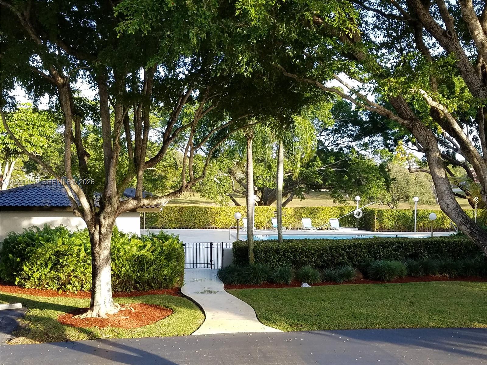 6161 Southwest 90th Court, Unit G2 Miami, FL 33173 - Photo 38 of 47 a view of a yard with plants and large trees