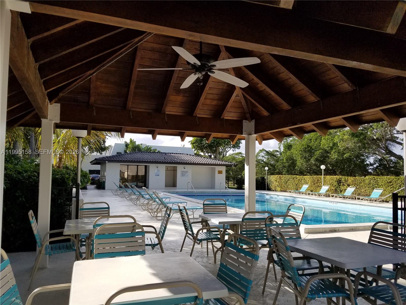 6161 Southwest 90th Court, Unit G2 Miami, FL 33173 - Photo 42 of 47 a view of a patio with table and chairs under an umbrella with a barbeque