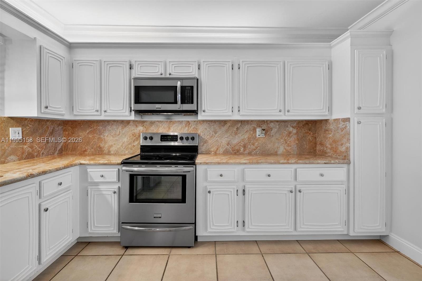 6161 Southwest 90th Court, Unit G2 Miami, FL 33173 - Photo 8 of 47 a kitchen with white cabinets and stainless steel appliances