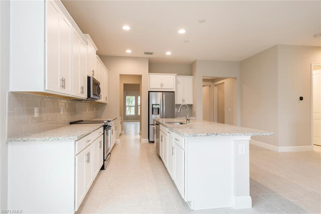 3509 Pilot Circle Naples, FL 34120 - Photo 12 of 32 a kitchen with stainless steel appliances granite countertop a sink stove and refrigerator