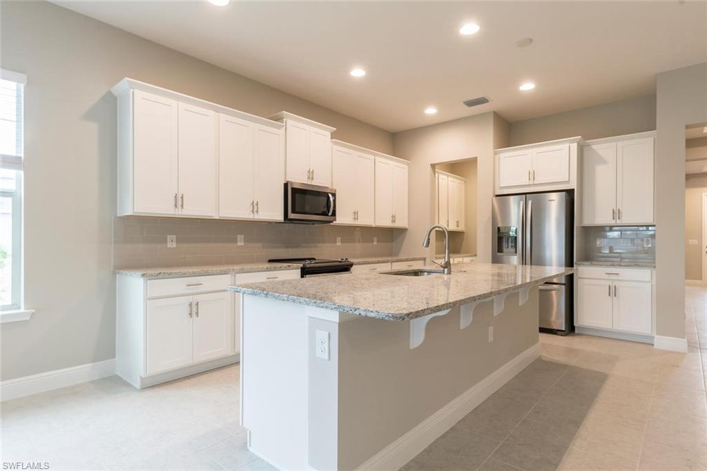 3509 Pilot Circle Naples, FL 34120 - Photo 13 of 32 a kitchen with stainless steel appliances granite countertop a refrigerator stove microwave and sink