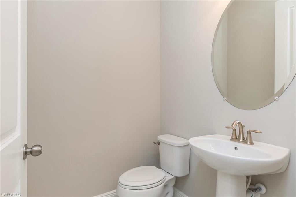 3509 Pilot Circle Naples, FL 34120 - Photo 14 of 32 a bathroom with a sink a toilet and mirror