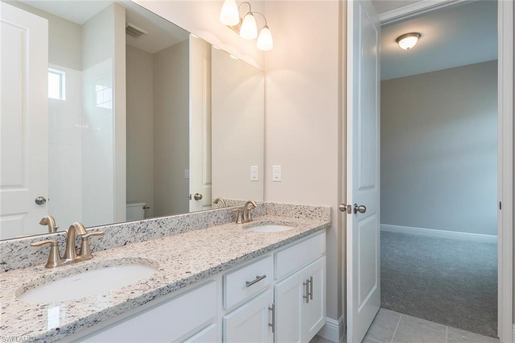 3509 Pilot Circle Naples, FL 34120 - Photo 22 of 32 a bathroom with a granite countertop sink and a mirror