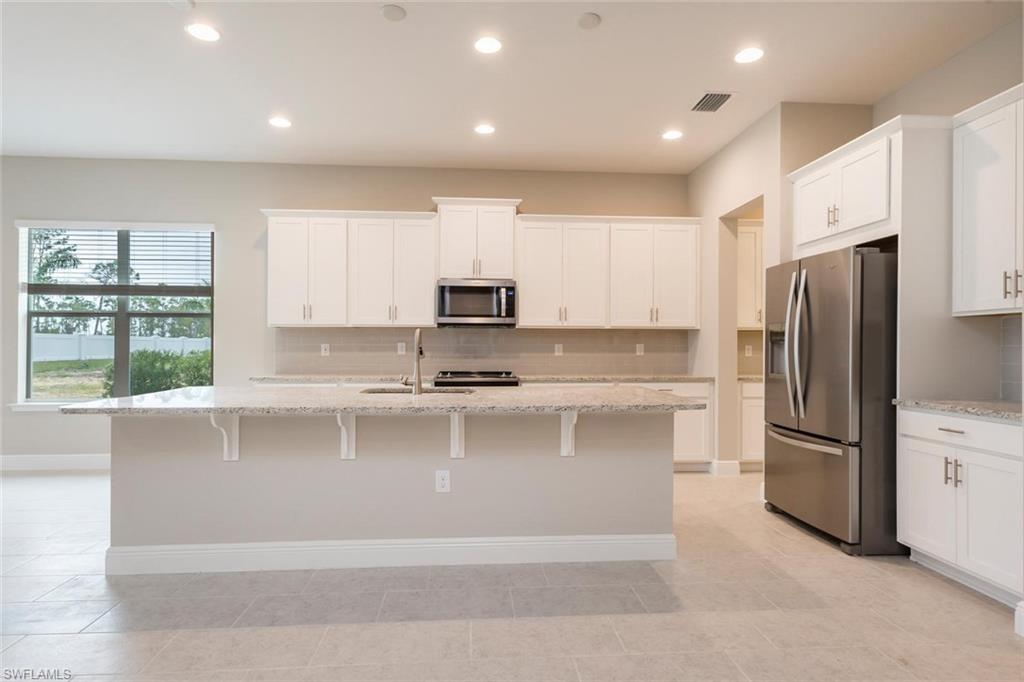 3509 Pilot Circle Naples, FL 34120 - Photo 9 of 32 a large kitchen with stainless steel appliances cabinets a sink and a window