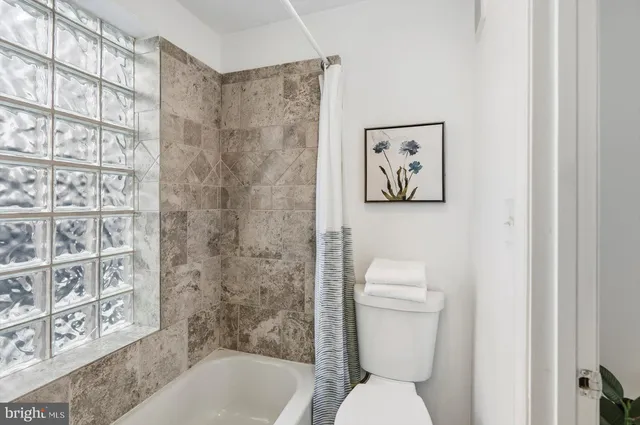 a bathroom with a toilet and a shower curtain