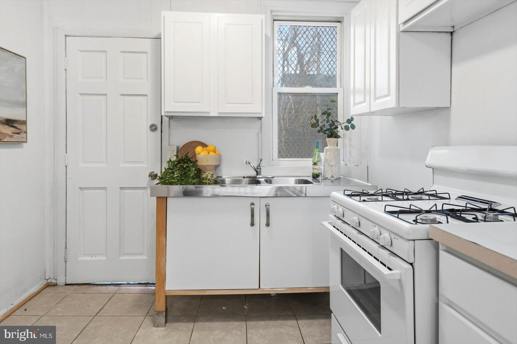 1017 Sterrett Street Baltimore, MD 21230 - Photo 8 of 29 a kitchen with granite countertop white cabinets and white appliances