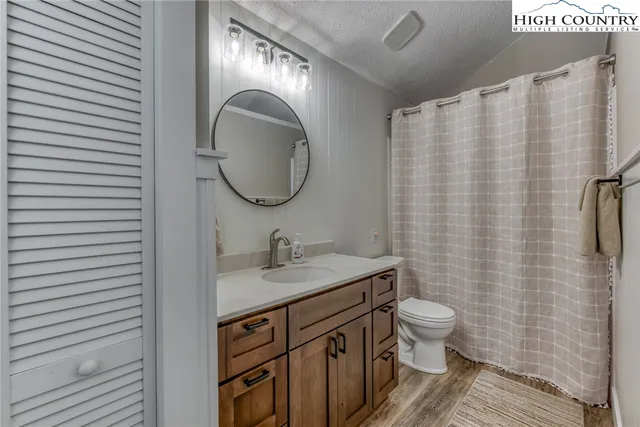 a bathroom with a granite countertop sink toilet and mirror