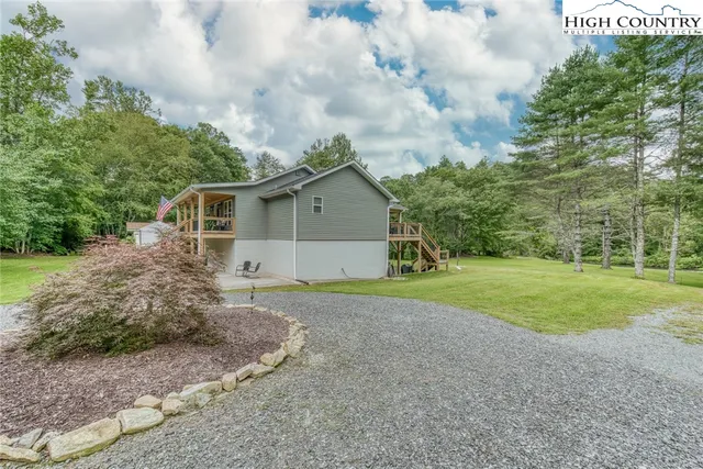 a backyard of a house with plants and large trees