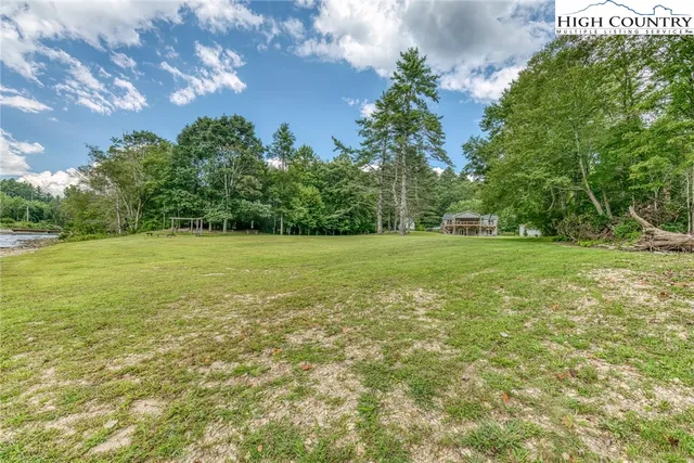 a view of a grassy field with trees in the background
