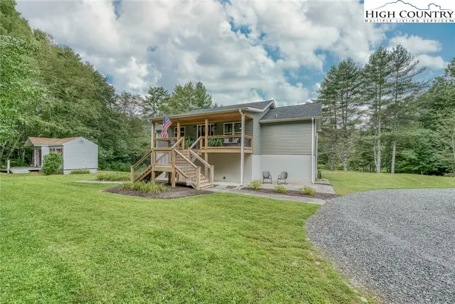 a view of a house with backyard and a tree
