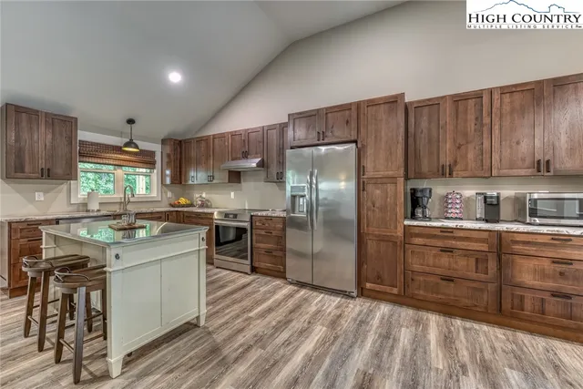 a kitchen with a refrigerator sink and cabinets