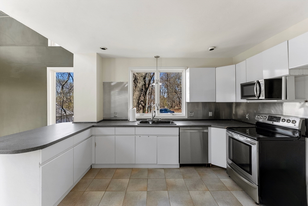 43 Farina Road Hull, MA 02045 - Photo 8 of 39 a kitchen with stainless steel appliances granite countertop a sink and stove top oven