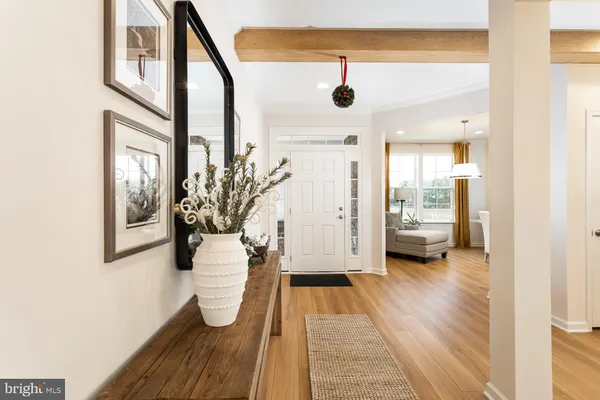 a view of a hallway with wooden floor and a living room