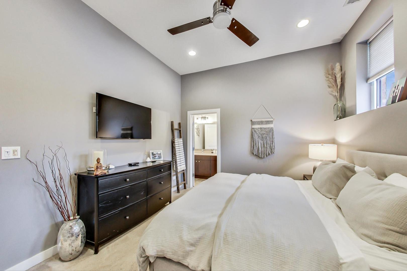 1256 North Cleaver Street, Unit 2E Chicago, IL 60642 - Photo 11 of 18 a bedroom with a bed and a flat screen tv