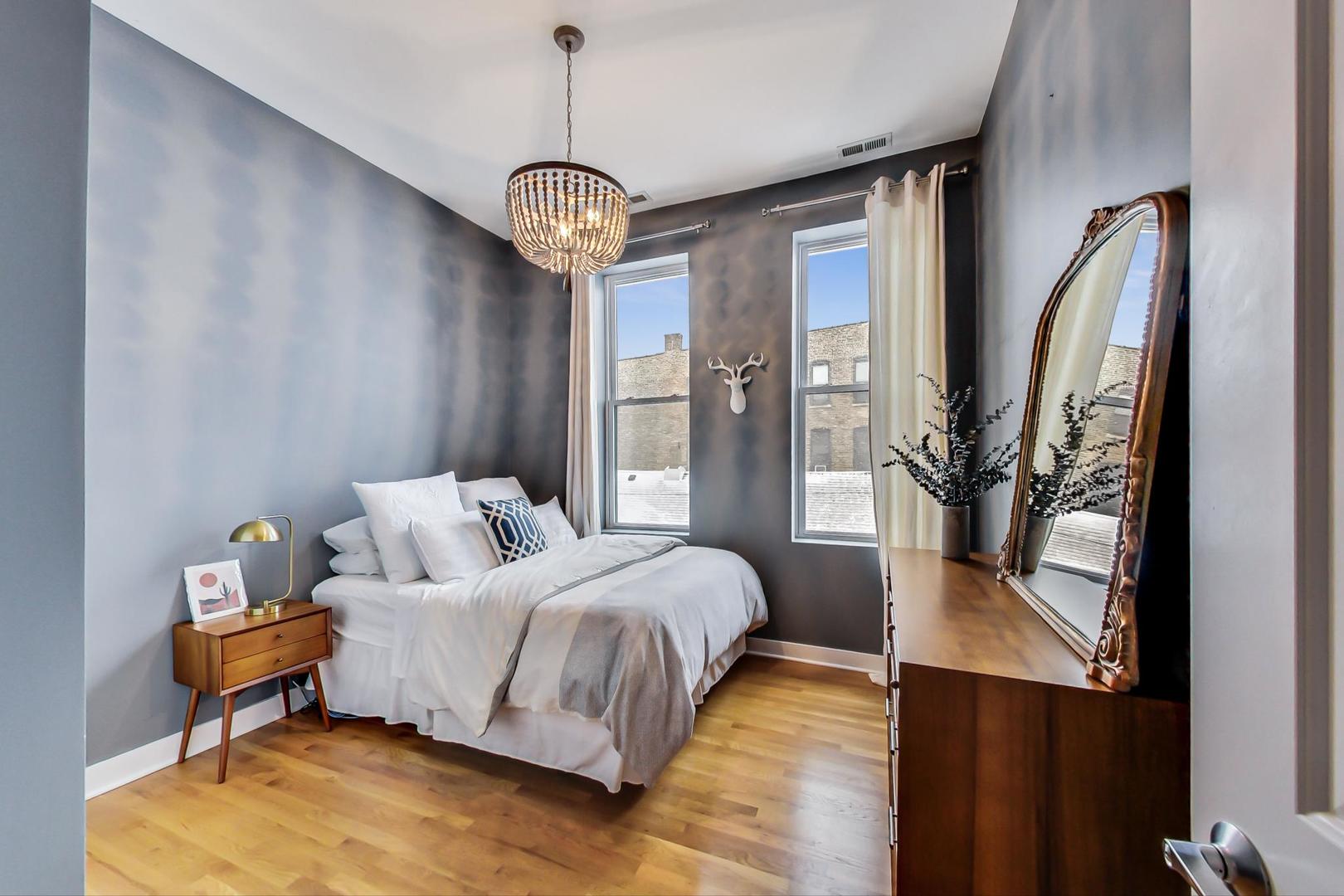 1256 North Cleaver Street, Unit 2E Chicago, IL 60642 - Photo 15 of 18 a bedroom with a bed wooden floor and a table