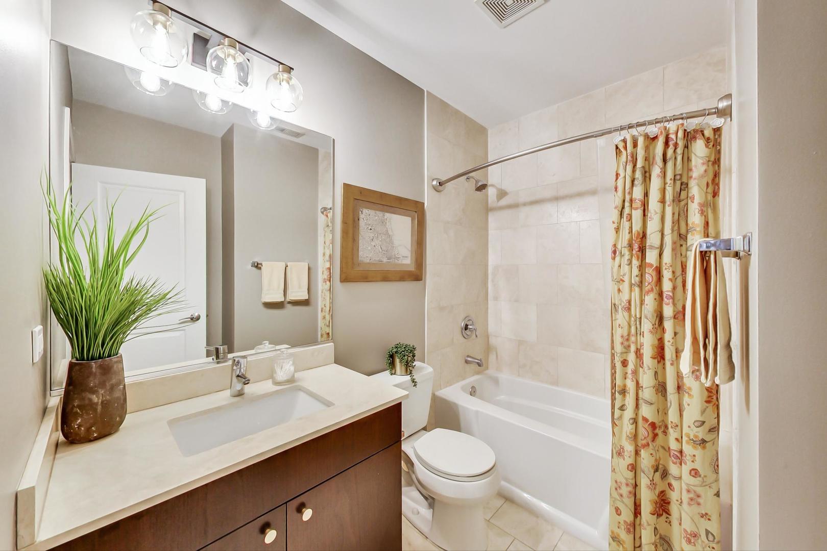 1256 North Cleaver Street, Unit 2E Chicago, IL 60642 - Photo 9 of 18 a bathroom with a granite countertop sink a toilet and shower