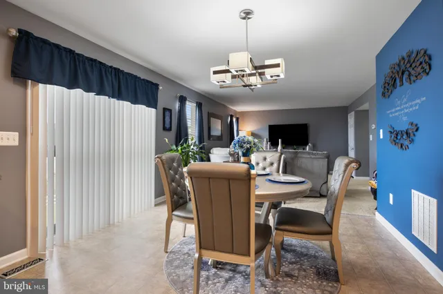 a view of a dining room with furniture a rug and wooden floor