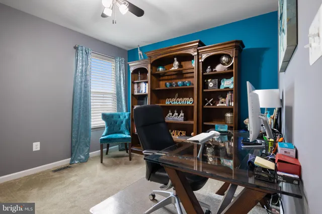 a view of a workspace with furniture and a window