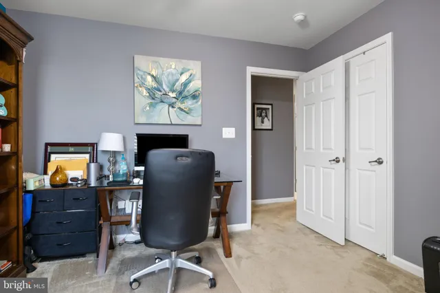 a view of a workspace with furniture and a window