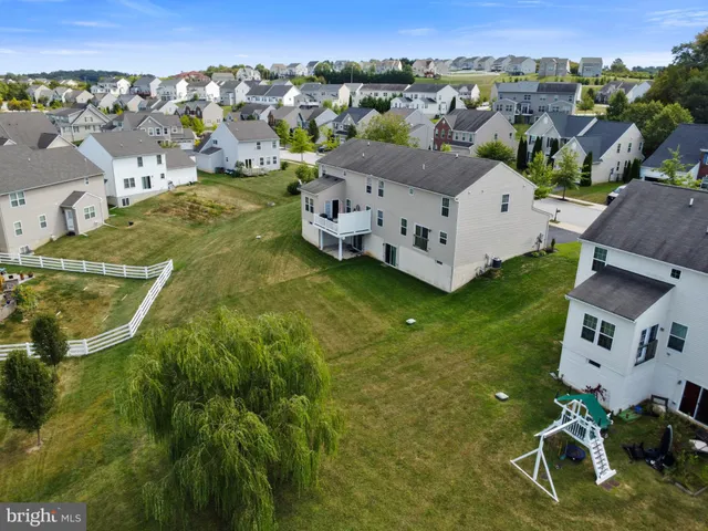 an aerial view of residential houses with outdoor space and trees