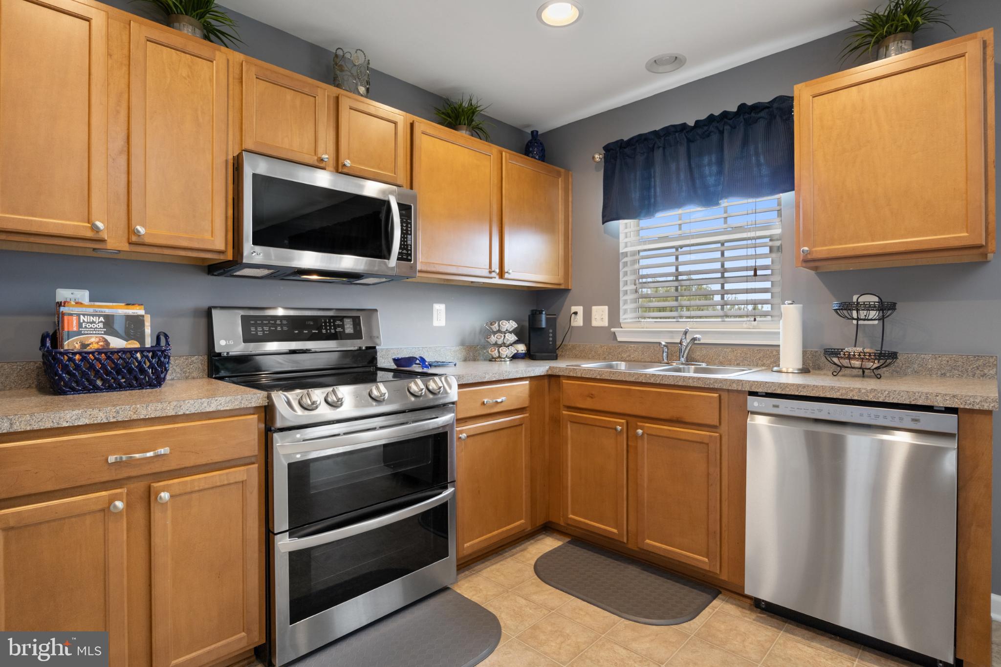 856 Countryside Road Seven Valleys, PA 17360 - Photo 10 of 47 a kitchen with stainless steel appliances granite countertop a sink a stove a microwave and wooden cabinets