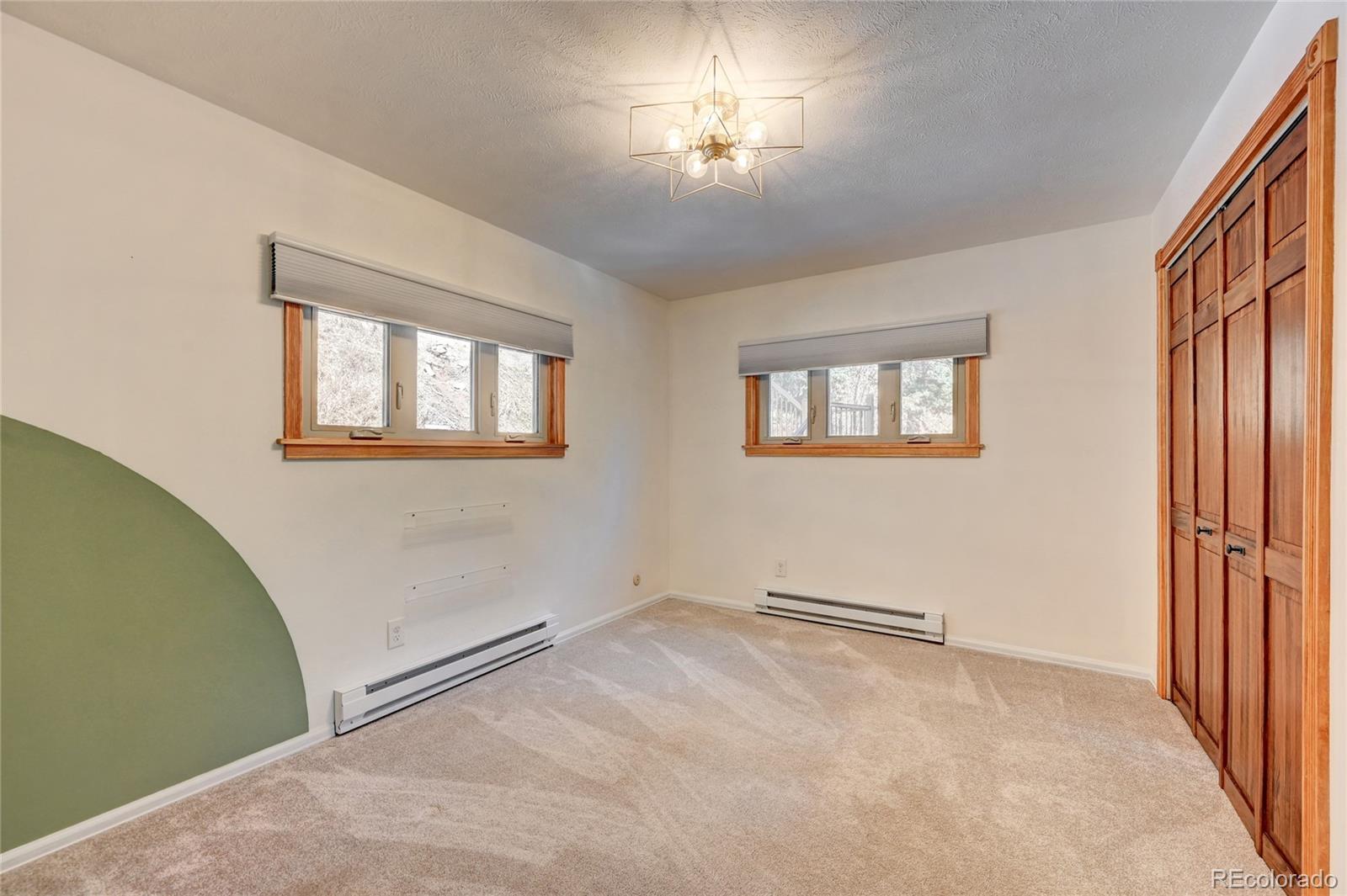 32856 Timber Ridge Road Evergreen, CO 80439 - Photo 11 of 41 wooden floor and windows in an empty room