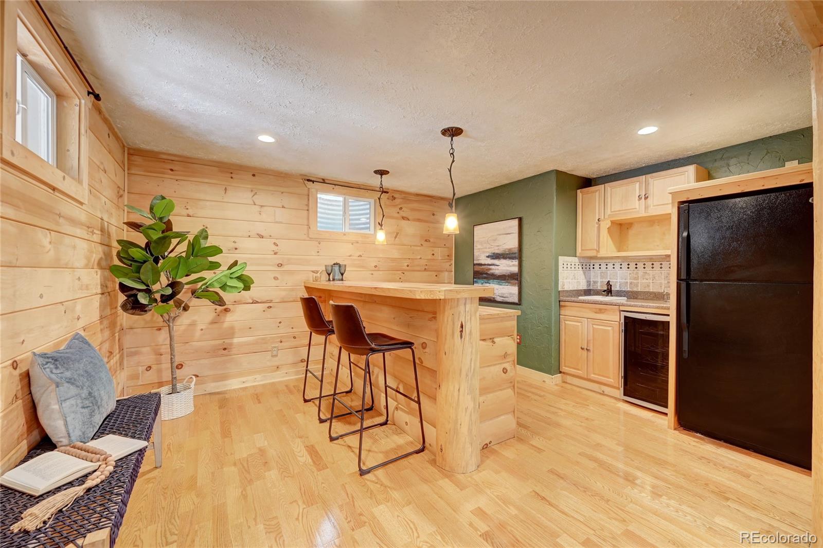 32856 Timber Ridge Road Evergreen, CO 80439 - Photo 19 of 41 a kitchen with stainless steel appliances kitchen island granite countertop a refrigerator a stove a microwave oven a dining table and chairs with wooden floor