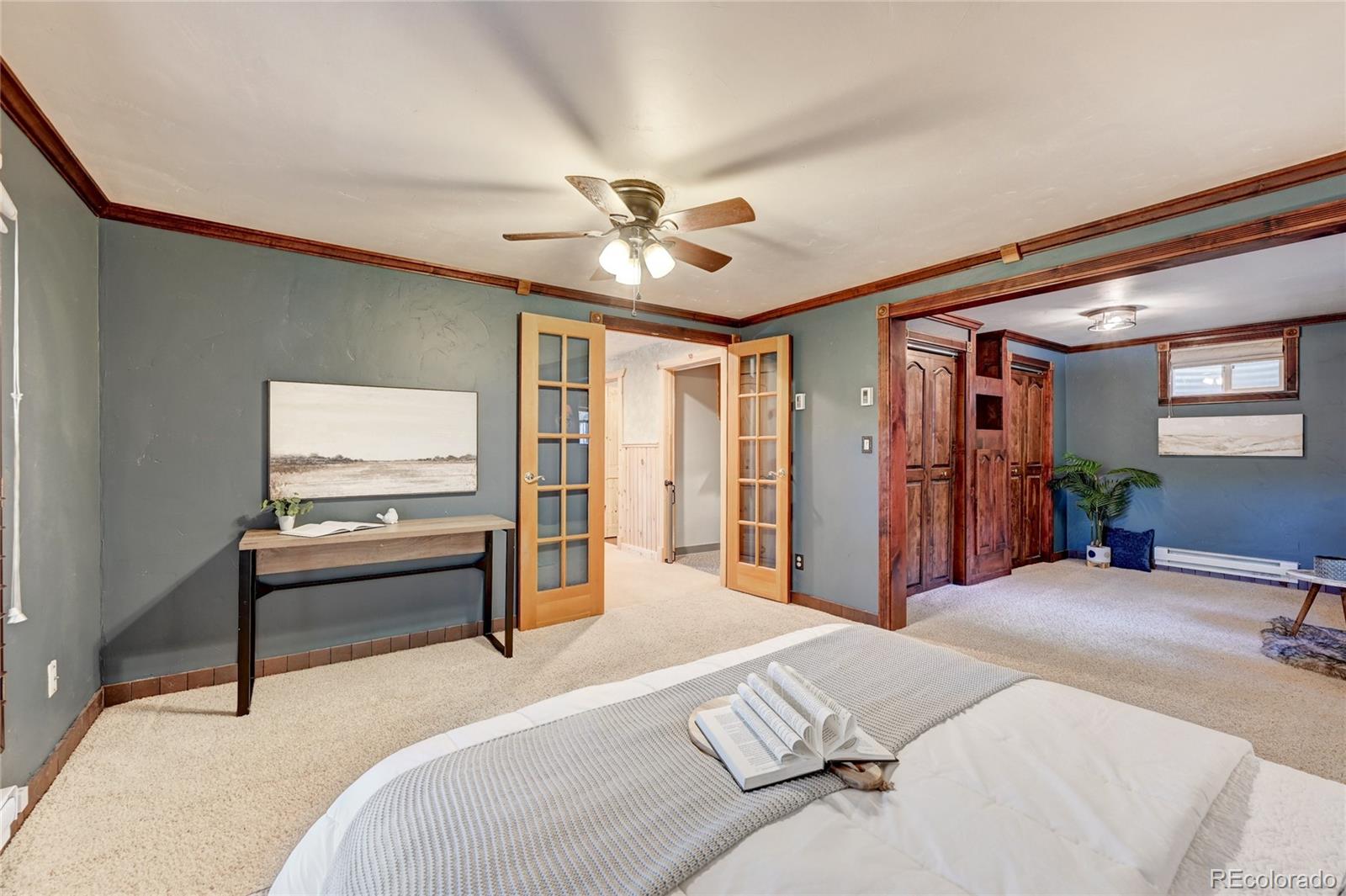 32856 Timber Ridge Road Evergreen, CO 80439 - Photo 24 of 41 a bedroom with a bed and a chandelier